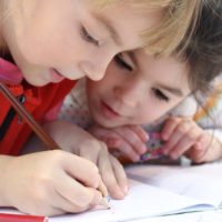 girls-on-desk-looking-at-notebook-159823 girls-on-desk-looking-at-notebook-159823